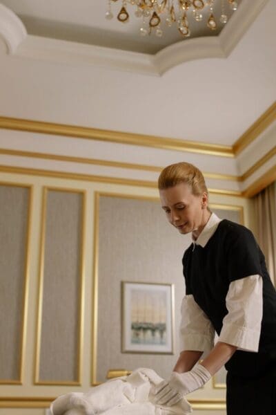 Hotel housekeeper preparing towels in a guest room